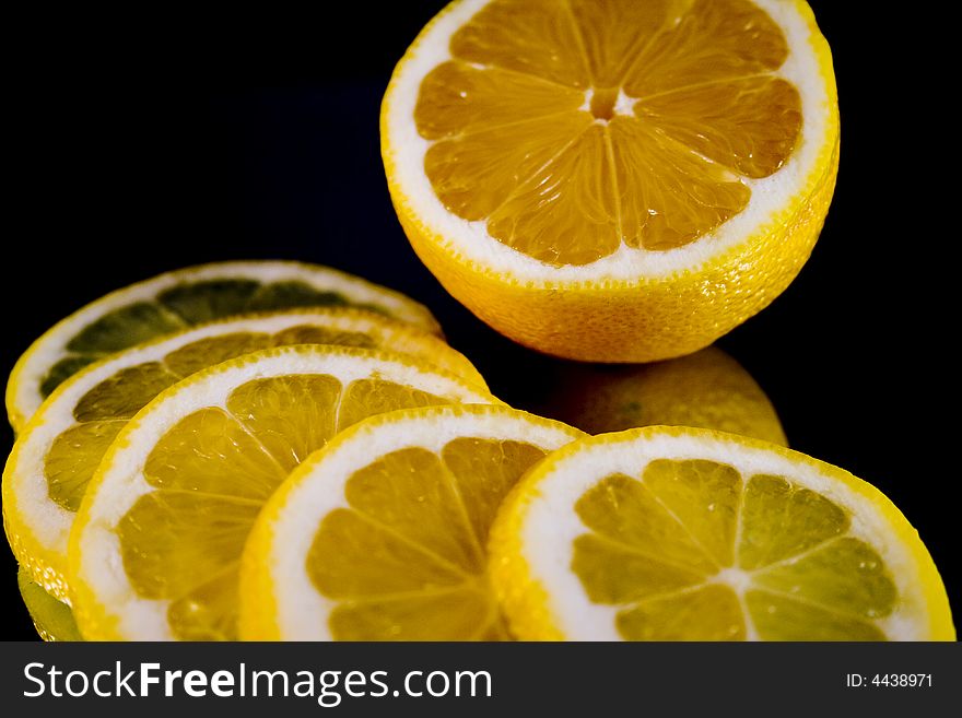 Lemon and Lime slices and halves against a dark background. Lemon and Lime slices and halves against a dark background