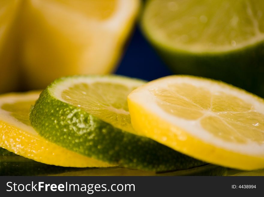 Lemon and Lime slices and halves against a dark background. Lemon and Lime slices and halves against a dark background