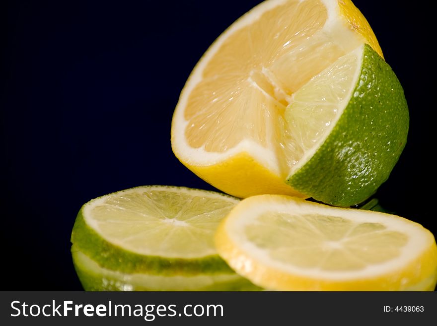 Lemon and Lime slices and halves against a dark background. Lemon and Lime slices and halves against a dark background