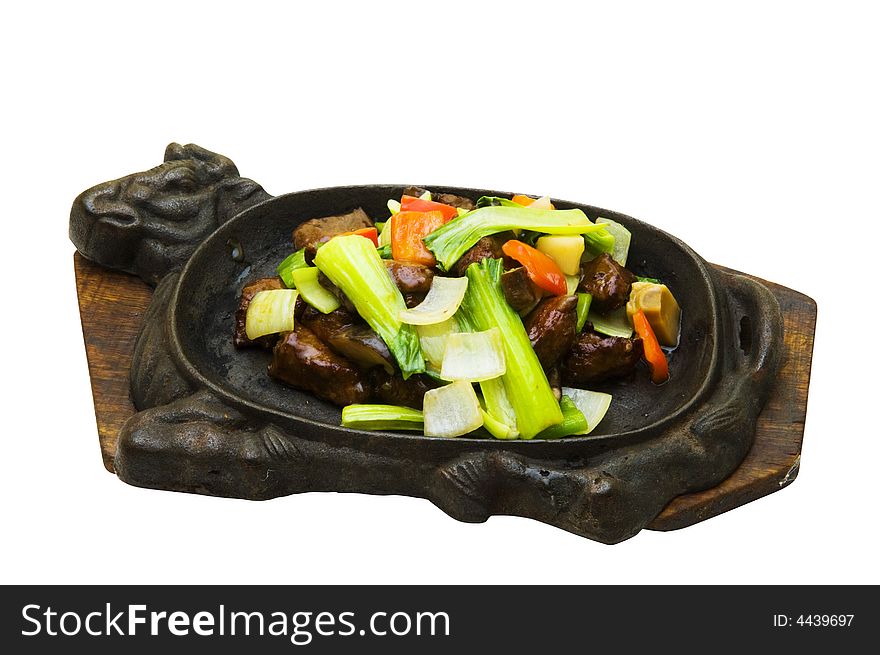 Fried meat with the vegetables on the frying pan