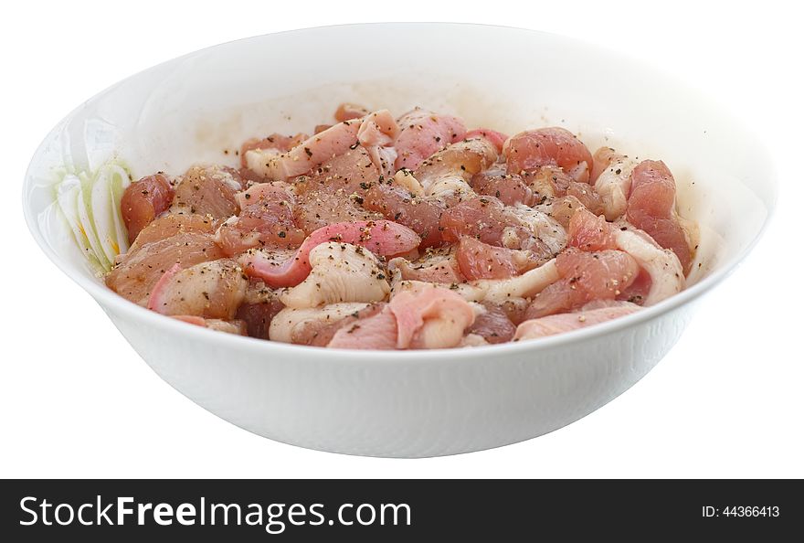 Diced fresh pork is marinated in a bowl with piper isolated on white background. Diced fresh pork is marinated in a bowl with piper isolated on white background