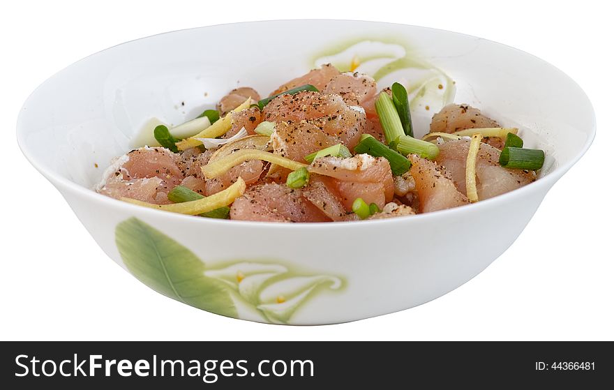 Diced fresh pork is marinated in a bowl with piper, ginger, shallot and garlic isolated on white background. Diced fresh pork is marinated in a bowl with piper, ginger, shallot and garlic isolated on white background