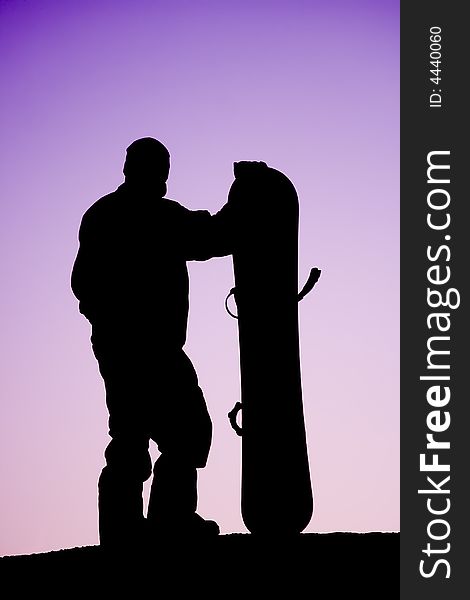 Male snowboarder on the purple sky background