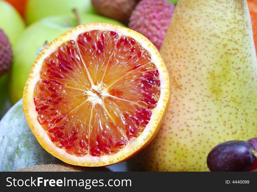 Half orange arranged in front of fresh fruits