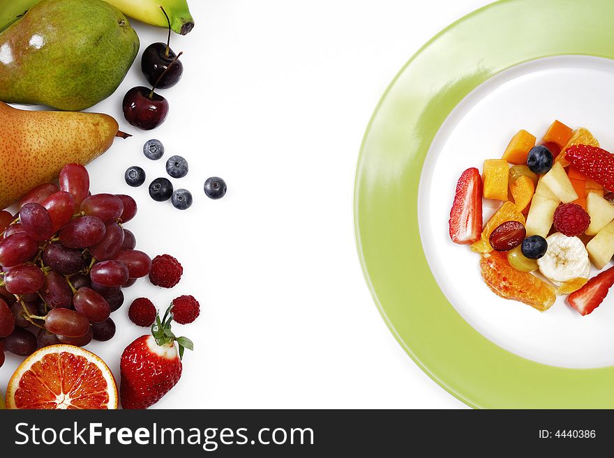 Fruit salad on a plate arranged with fresh fruits