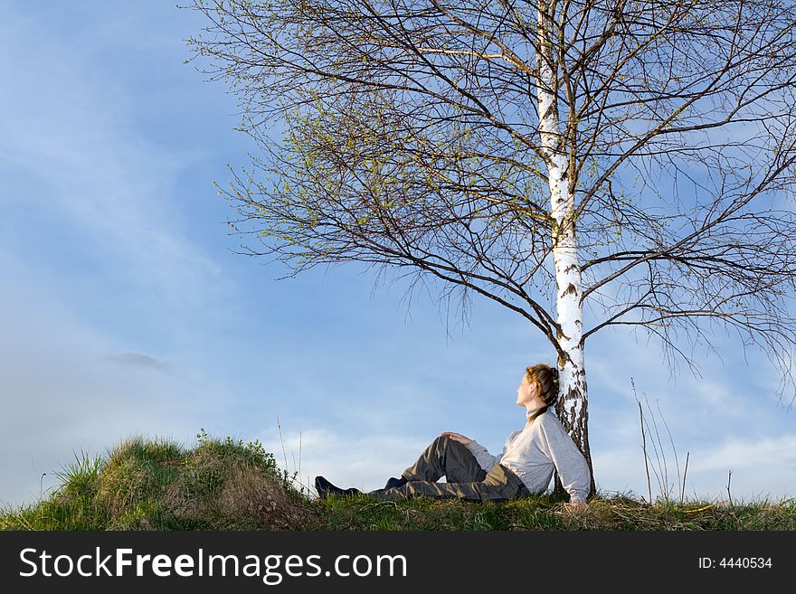 Woman under the birch at field