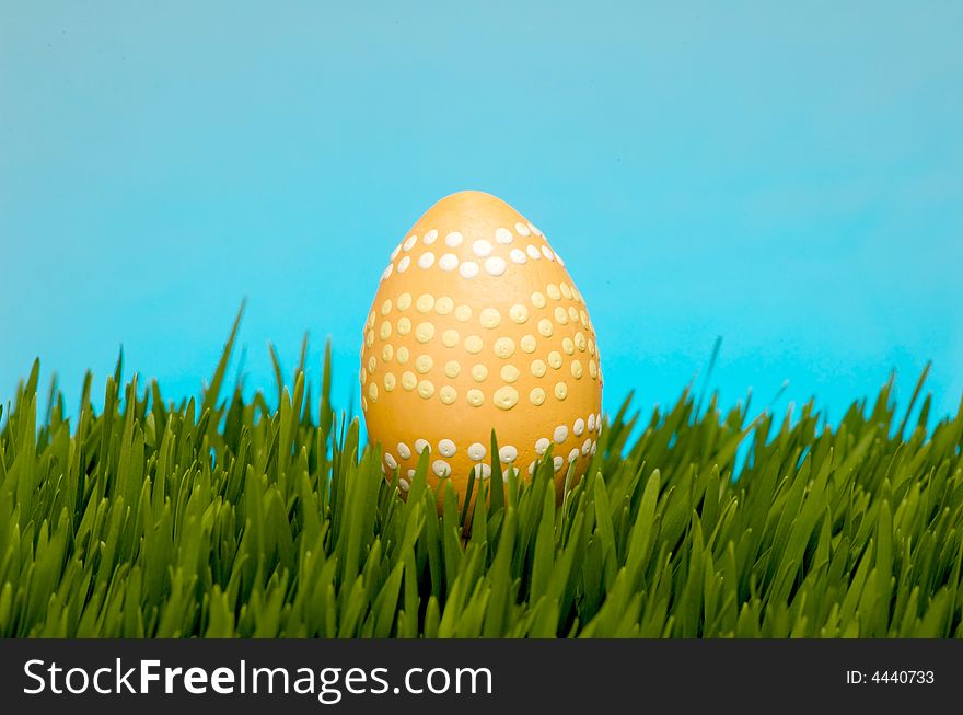 An image of a pastel easter egg in lush grass