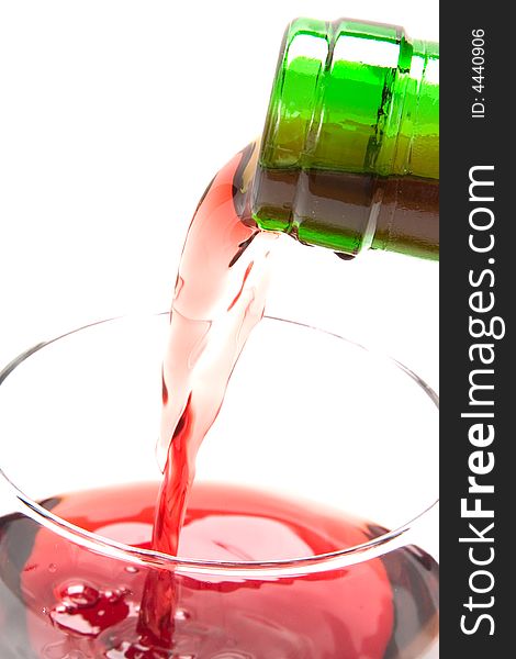 Red wine poured from a green bottle