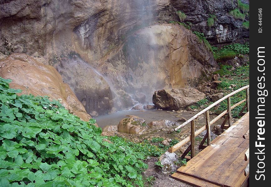 Detail of small wooden bridge located near waterfall bottom