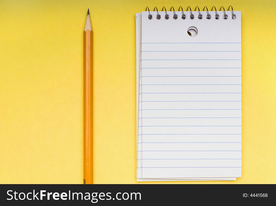 Pencil And Blank Notebook On Yellow