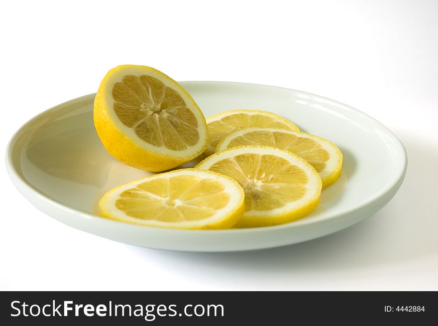 Sliced lemon on a plate on a white background