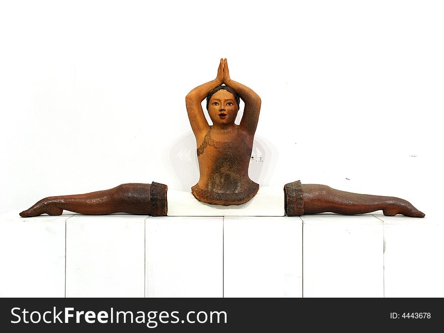 A pottery figure of a woman playing yoga. A pottery figure of a woman playing yoga.