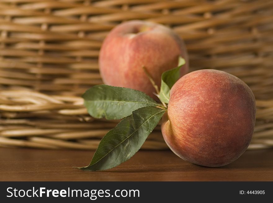 Naturmort with peach and basket on the table.