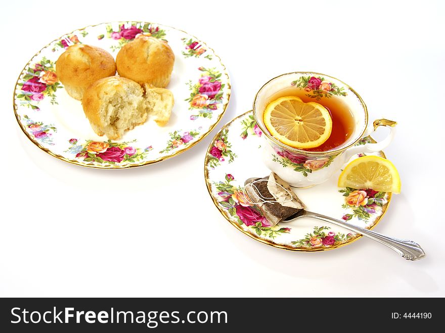 Overhead view of lemon tea, and cake muffins on beautiful china dishes. Overhead view of lemon tea, and cake muffins on beautiful china dishes.