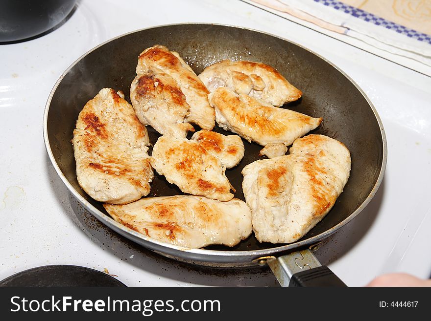 Golden brown fried chicken in the pan on electric stove. Golden brown fried chicken in the pan on electric stove