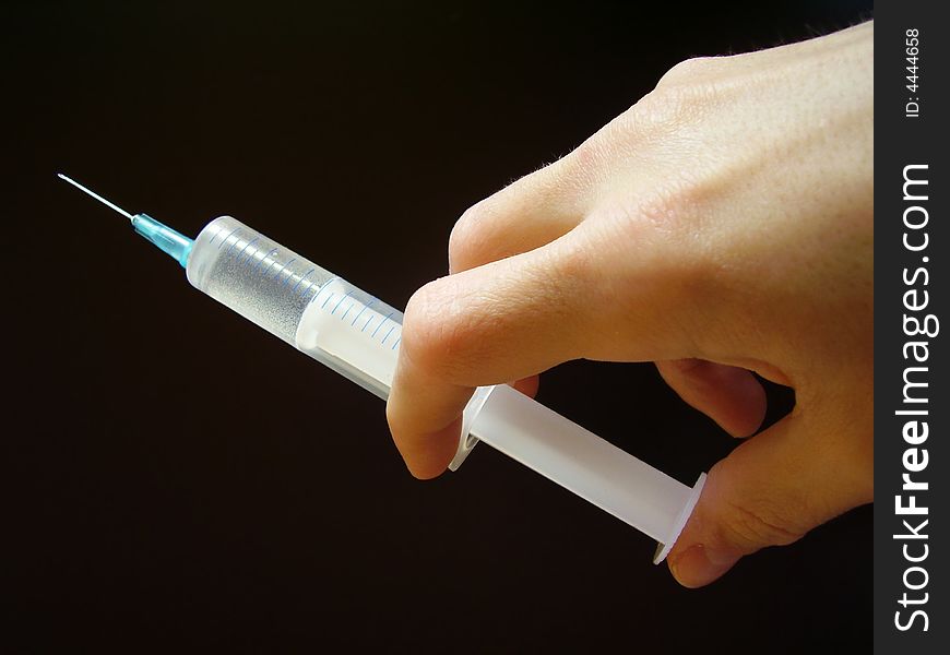 Hand with syringe on black background. Hand with syringe on black background.