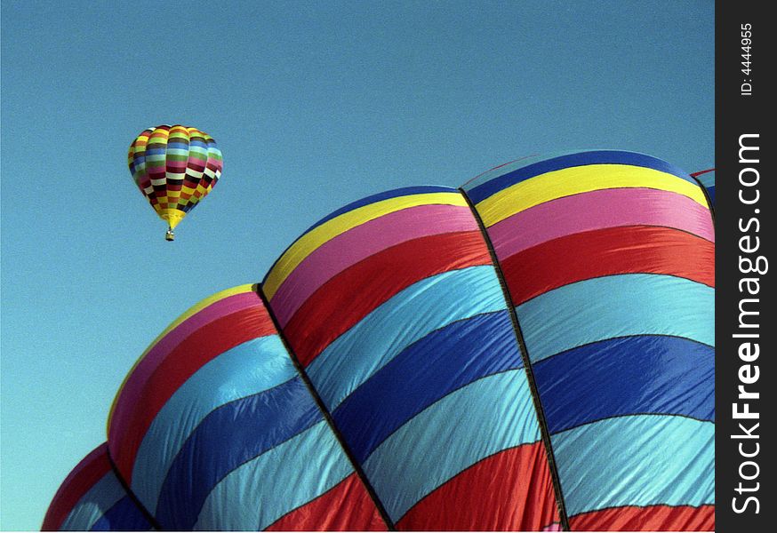 Dramatic hot air balloons rising into the blue sky. Dramatic hot air balloons rising into the blue sky