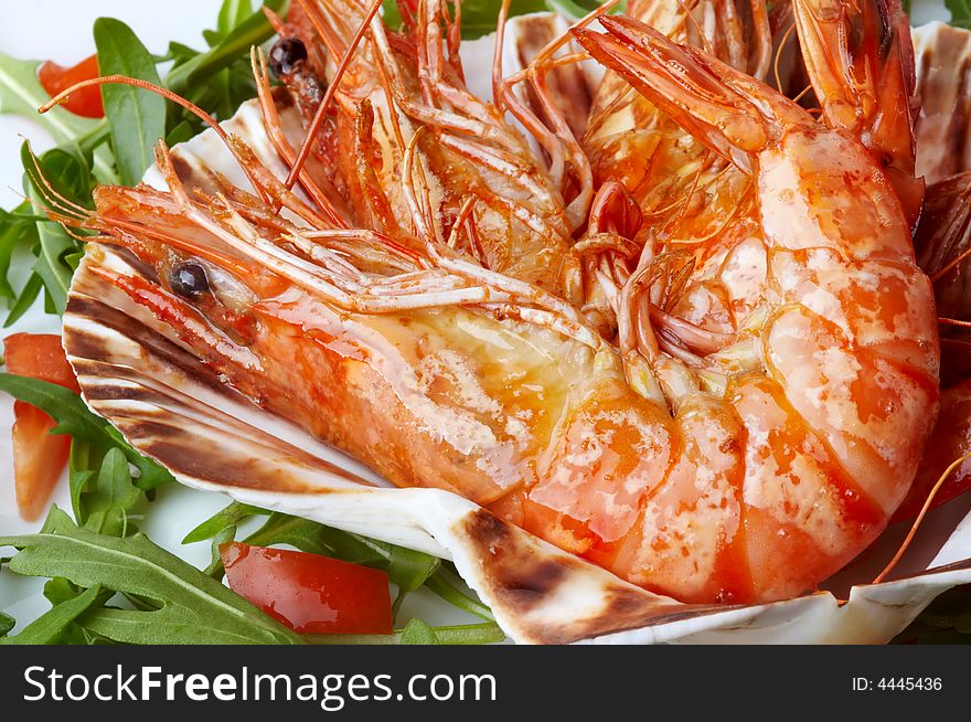 Large shrimps on shell, rocket salad and slices of tomato. Large shrimps on shell, rocket salad and slices of tomato