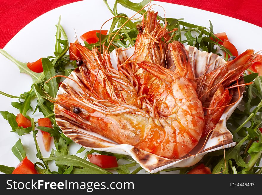 Large shrimps on shell, rocket salad and slices of tomato. Large shrimps on shell, rocket salad and slices of tomato