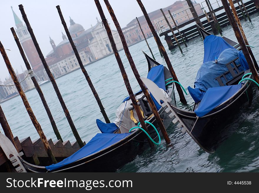 Gondolas parked in a row on canal, Venice, Veneto region, Italy. Gondolas parked in a row on canal, Venice, Veneto region, Italy.