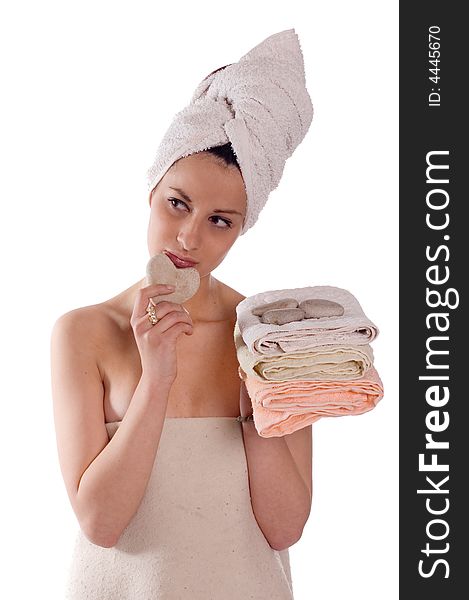 Young woman with a hot stone in heart shape on towel ready for massage