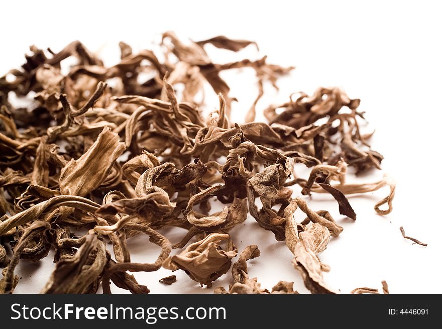 Dried leaves of black tea on white background