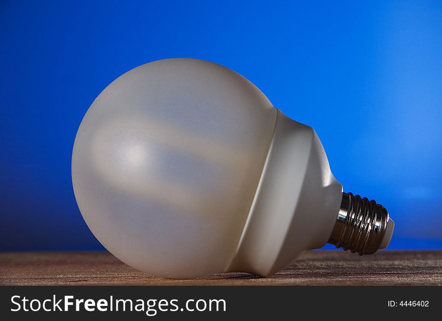 A energy saver bulb on a blue background against global warming. A energy saver bulb on a blue background against global warming