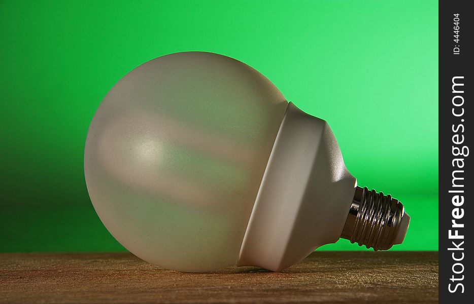 A energy saver bulb on a green background against global warming. A energy saver bulb on a green background against global warming