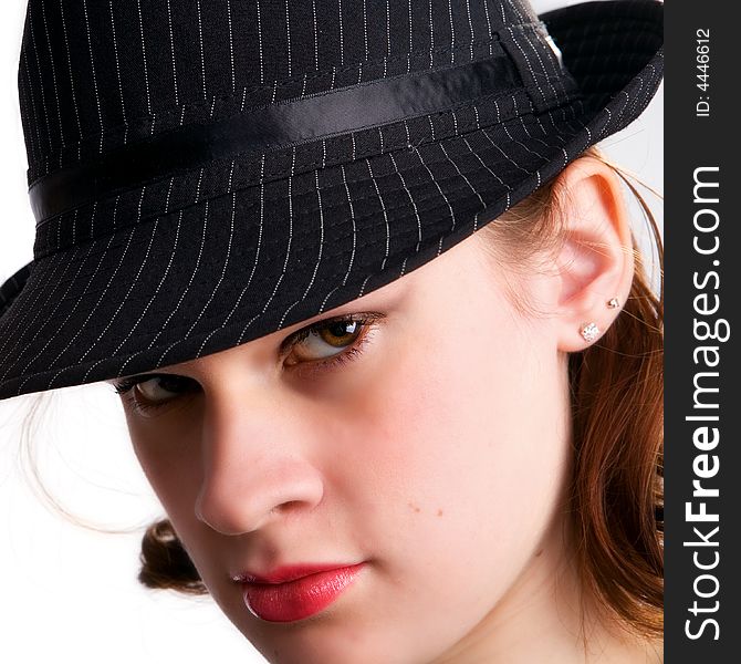 Portrait of a serios teen girl peering from under a fedora hat. Portrait of a serios teen girl peering from under a fedora hat.