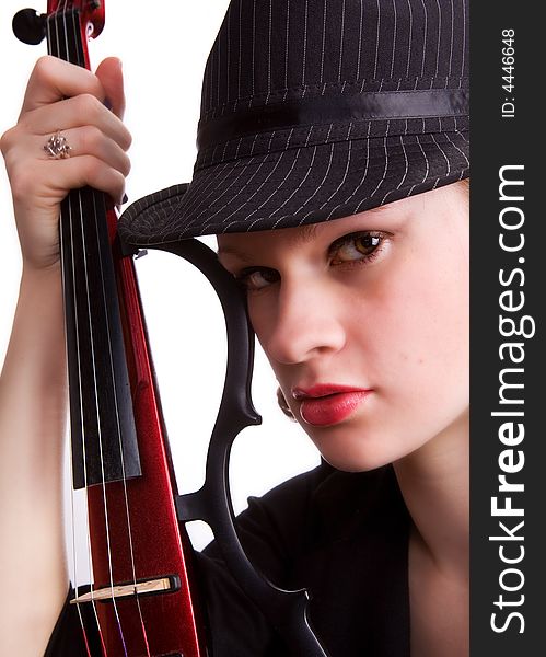 Portrait of a serios teen girl in fedora hat holding her electric guitar. Portrait of a serios teen girl in fedora hat holding her electric guitar.