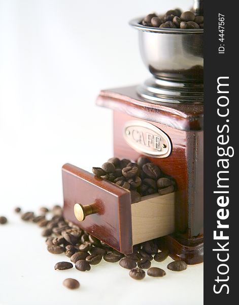 A nice small coffee grinder with coffee seeds. A nice small coffee grinder with coffee seeds