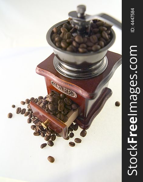A nice small coffee grinder with coffee seeds. A nice small coffee grinder with coffee seeds