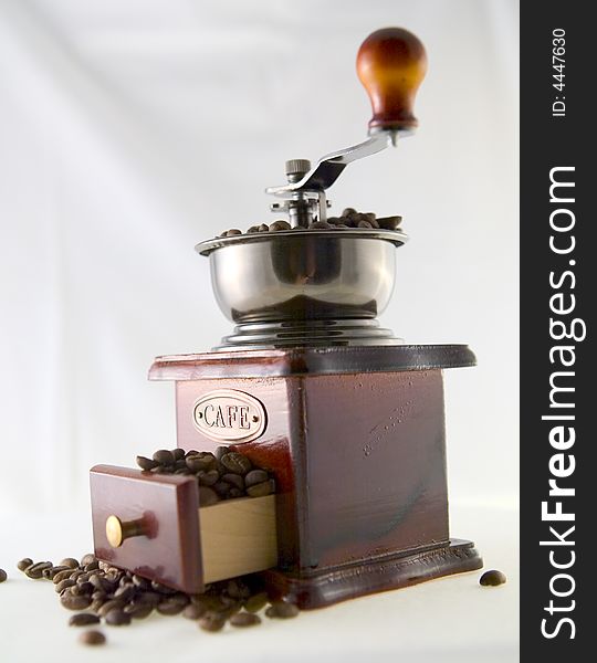 A nice small coffee grinder with coffee seeds. A nice small coffee grinder with coffee seeds