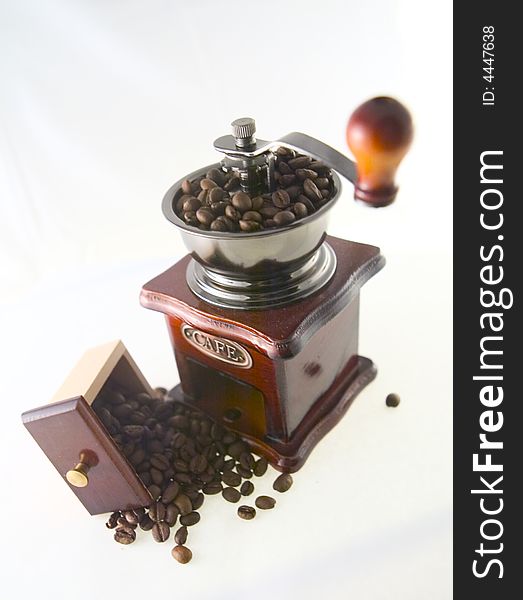 A nice small coffee grinder with coffee seeds. A nice small coffee grinder with coffee seeds