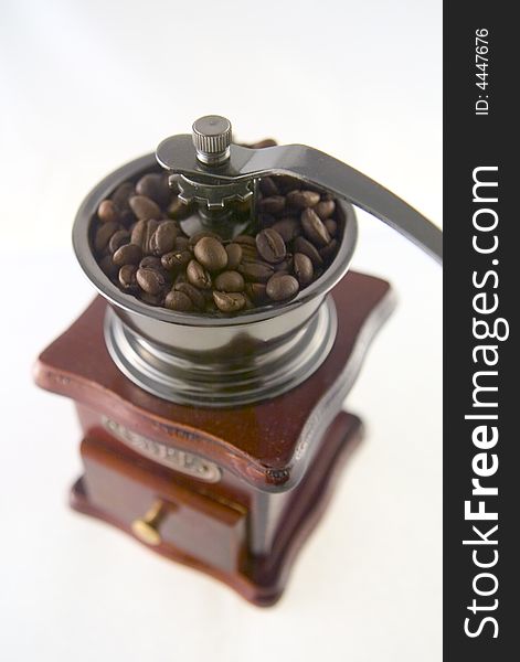A nice small coffee grinder with coffee seeds. A nice small coffee grinder with coffee seeds