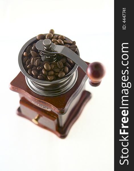 A nice small coffee grinder with coffee seeds. A nice small coffee grinder with coffee seeds