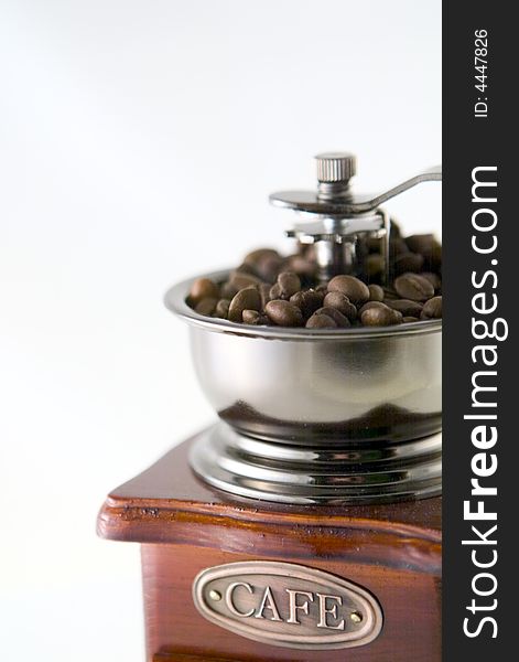 A nice small coffee grinder with coffee seeds. A nice small coffee grinder with coffee seeds