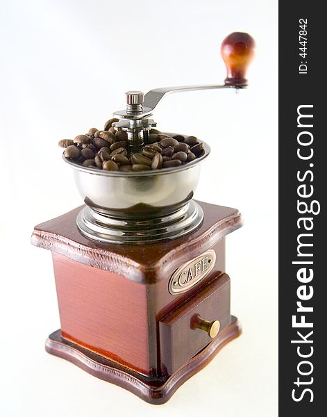 A nice small coffee grinder with coffee seeds. A nice small coffee grinder with coffee seeds