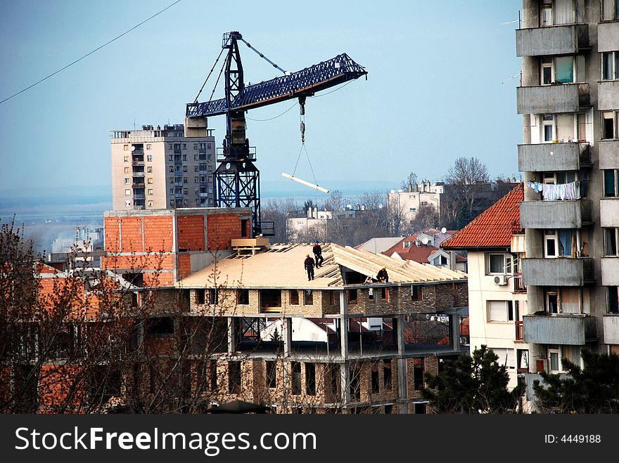 Workers on a roof - lifting crane