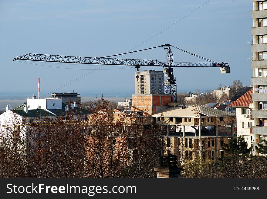 Workers on a roof of brick building with lifting crane. Workers on a roof of brick building with lifting crane