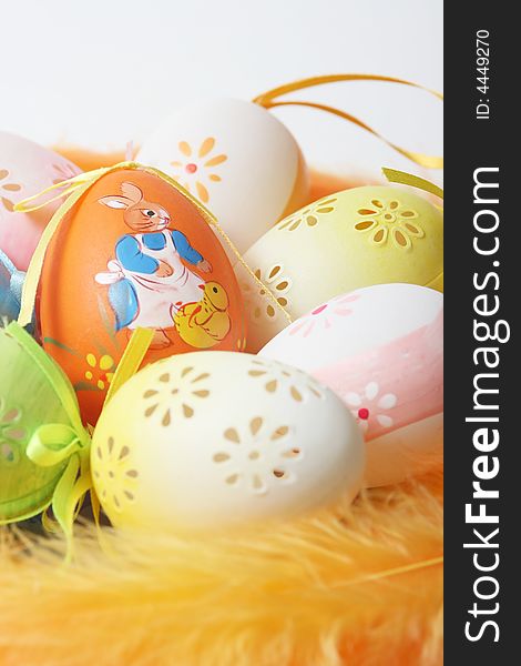 Easter eggs on yellow and orange feathers.