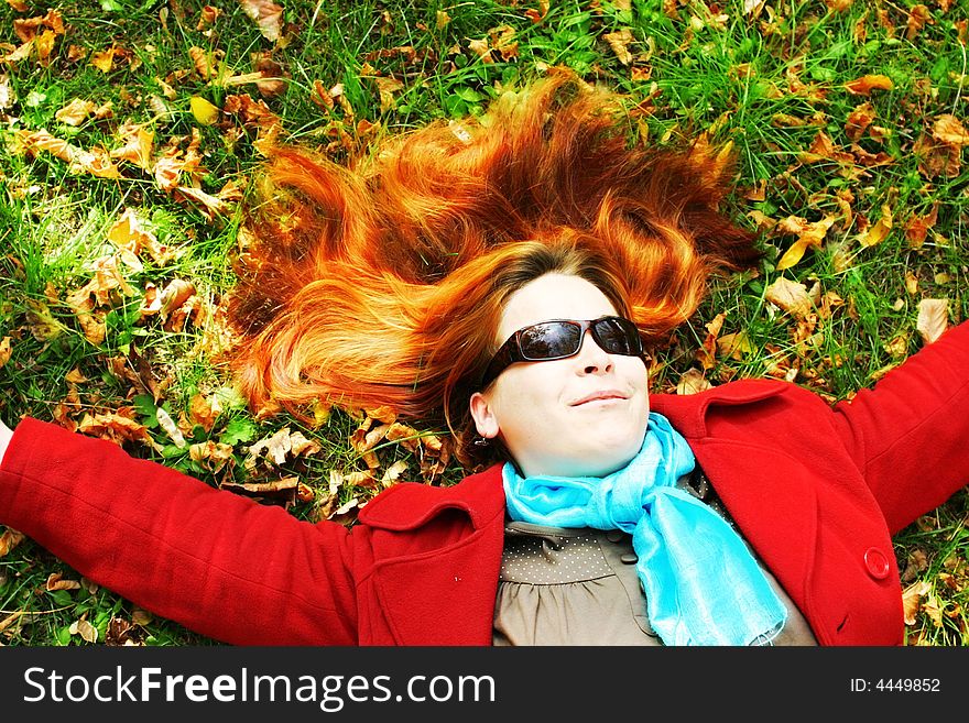 Red-haired girl laying in the grass. Red-haired girl laying in the grass.