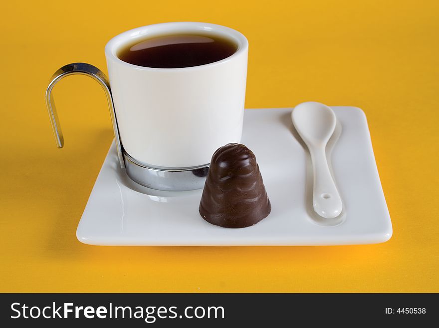 Tea has a yellow background with chocolates. Tea has a yellow background with chocolates