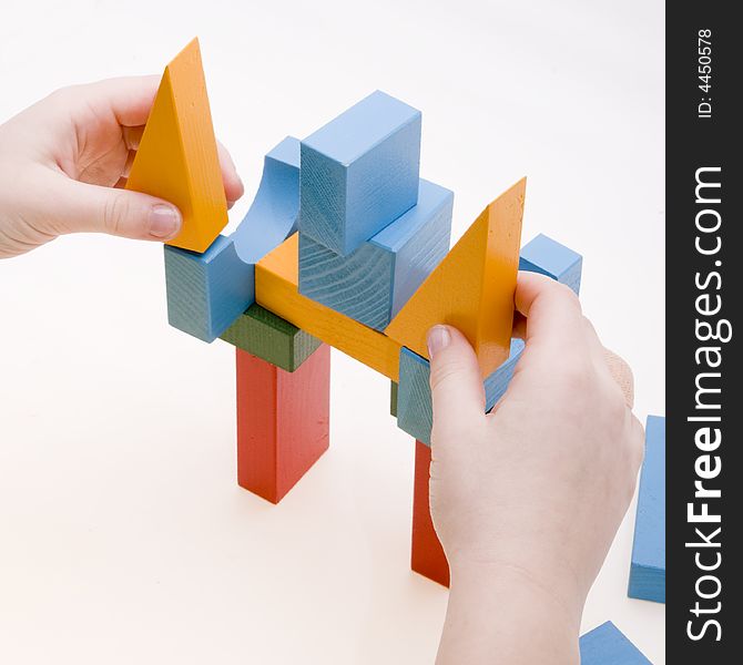 Child is playing with wooden blocks - making a building