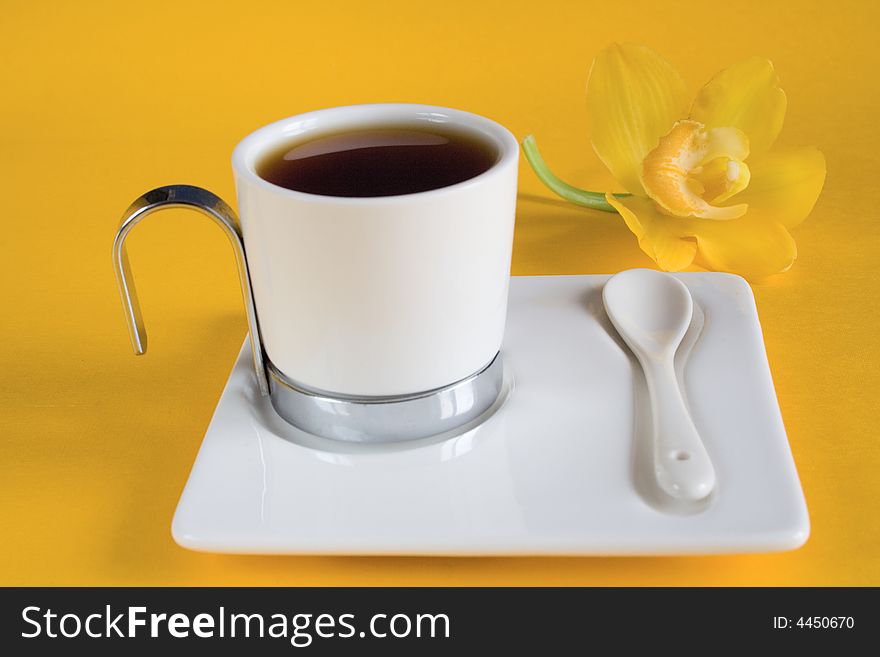 Tea has a yellow background with orchids. Tea has a yellow background with orchids