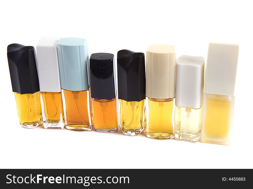 A row of colorful perfume bottles isolated on white