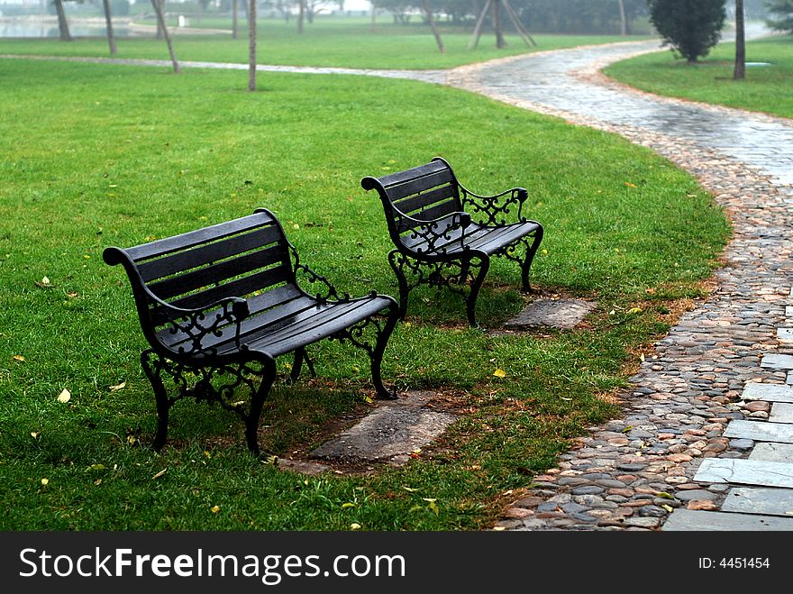 This is a stone road in the Park.It is two chair side the path.After a rain,thd path is waterish. This is a stone road in the Park.It is two chair side the path.After a rain,thd path is waterish.