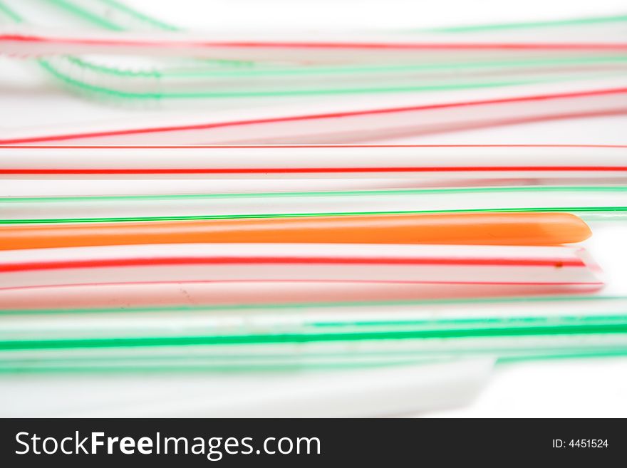 Multicolored tubes from juice on white background