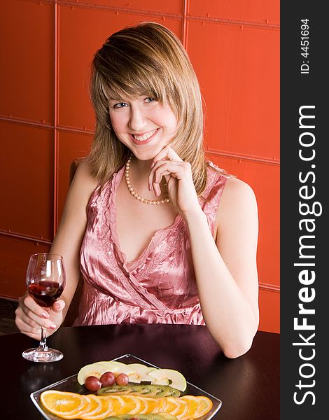 Young woman with wine glass on red background