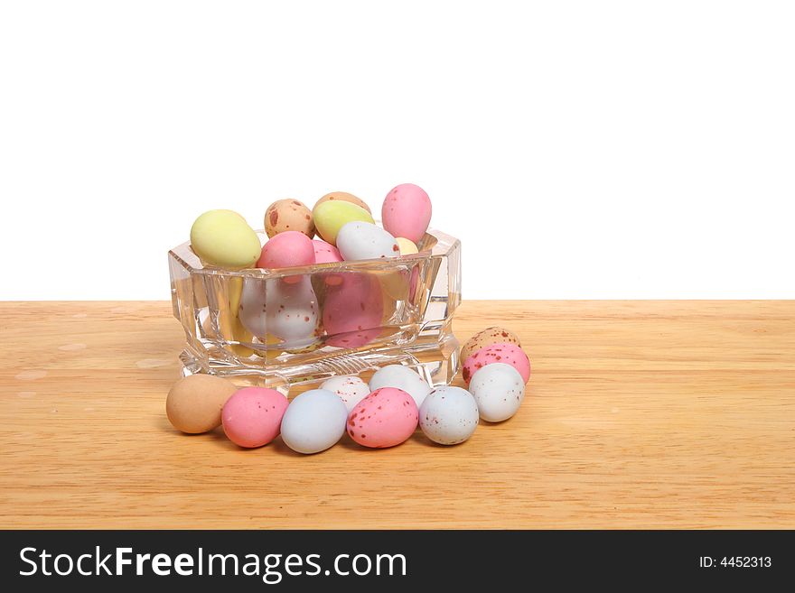 Mini Easter Eggs in a glass bowl on a wooden board